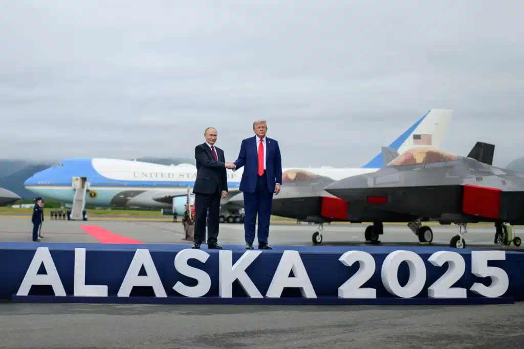 Trump–Putin Alaska Summit 2025: Key Insights and What It Means for India 2 Donald Trump and Vladimir Putin shake hands at Alaska 2025 summit with Air Force One and fighter jets in the background.